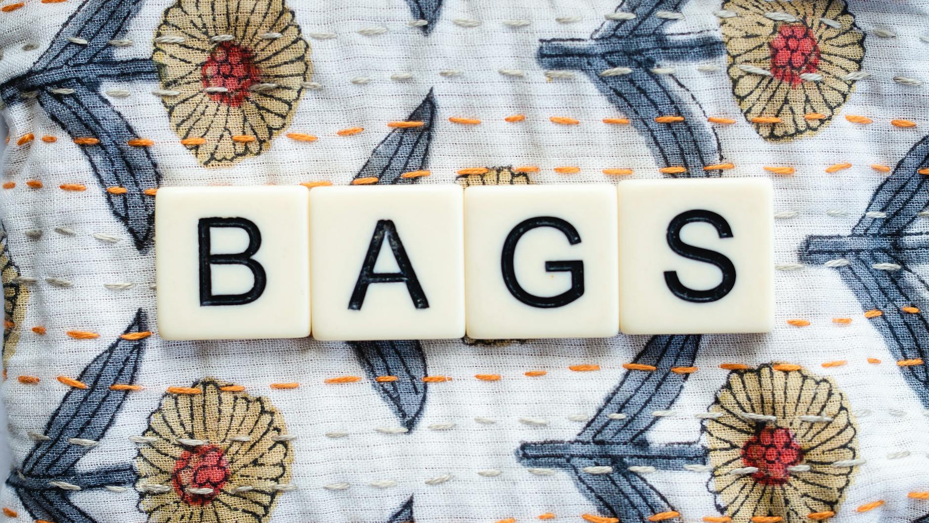 Jak uszyć pokrowce na buty z materiału i chronić je w podróży Literki z napisem BAGS na kwiecistym, haftowanym materiale