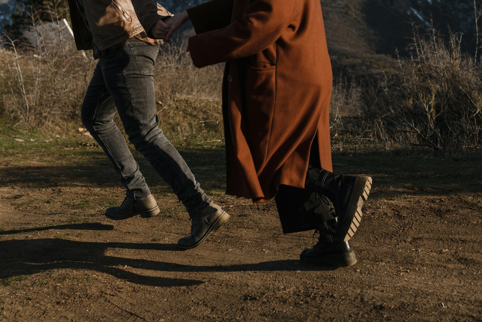 Para w płaszczach i zimowych butach spaceruje w słoneczny dzień