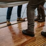 Skórzane męskie buty na mokrym drewnianym pokładzie jachtu