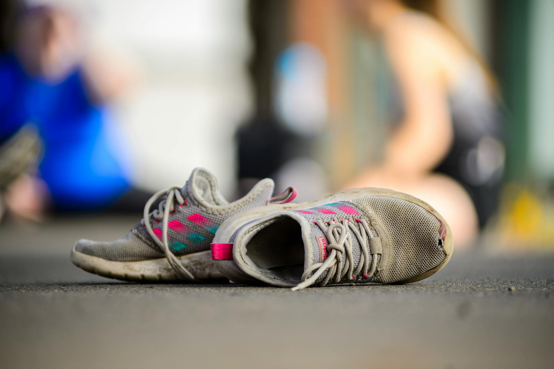 Zbliżenie znoszonych sportowych butów na ulicy w letnim miejskim tłumie