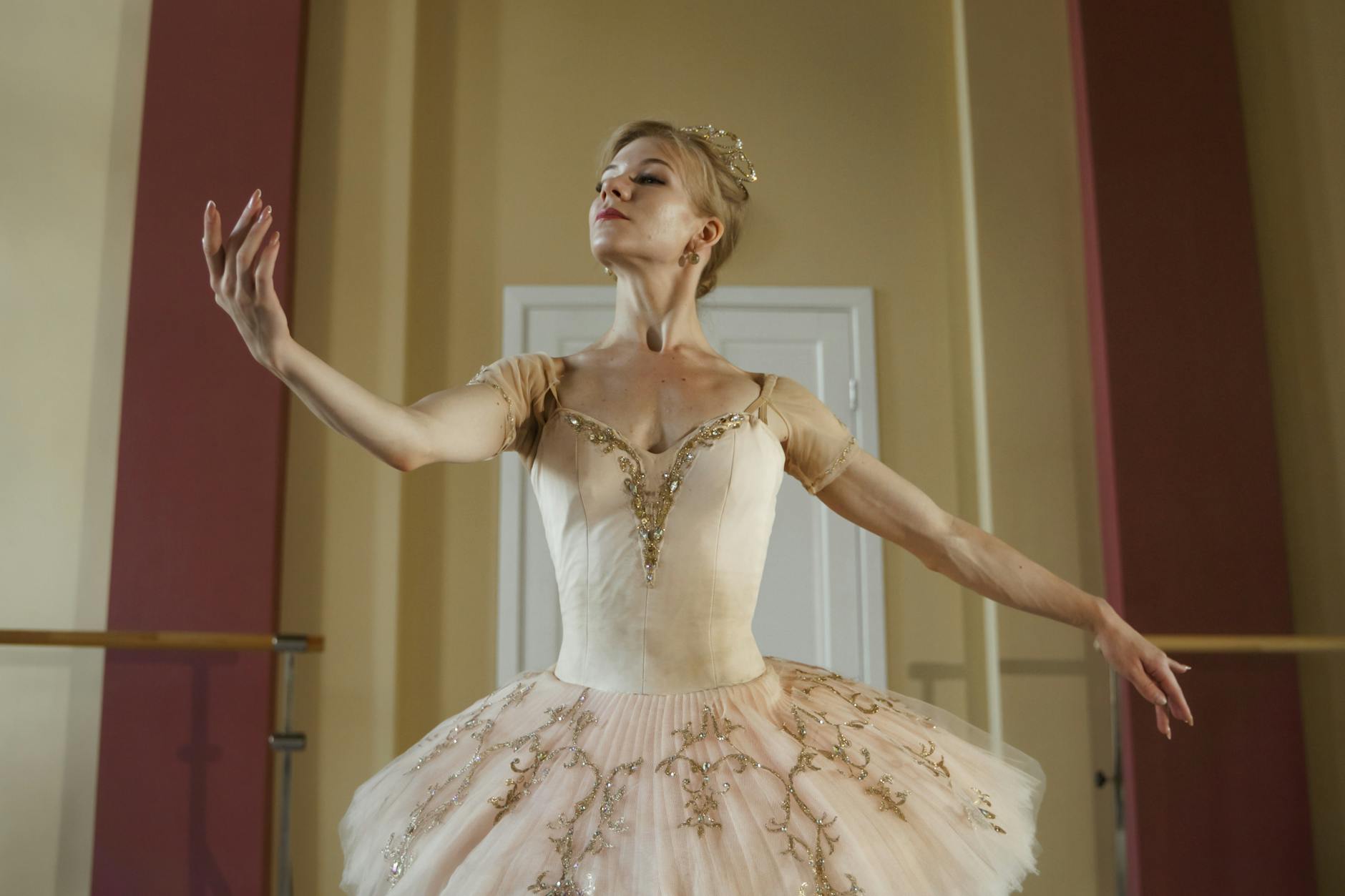 Baletnica w różowej spódniczce tutu pozuje w jasnym wnętrzu