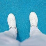 Białe damskie sneakersy do dresów na intensywnie niebieskim tle z góry