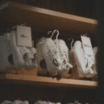 Białe damskie sneakersy na drewnianych półkach w nowoczesnym sklepie