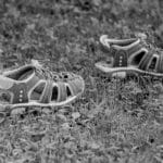 Czarno-białe miejskie klapki leżące na trawie z bliska