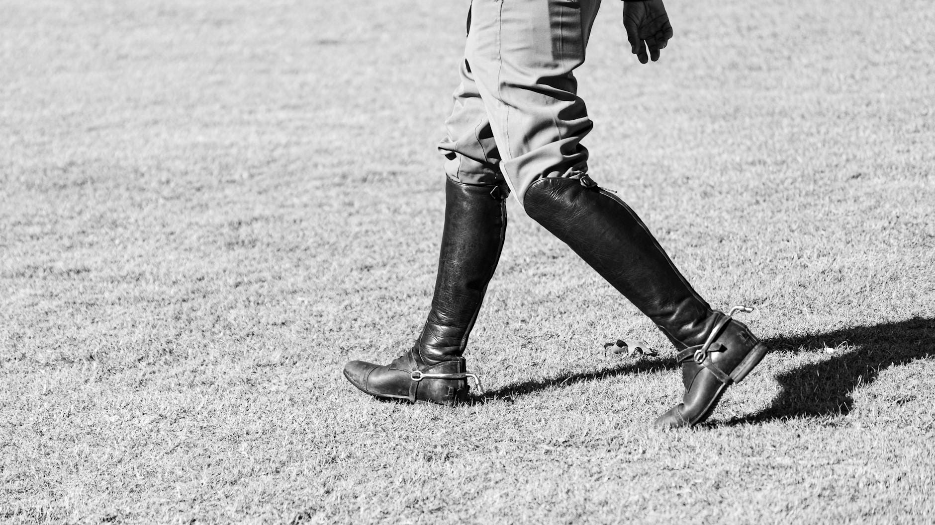 Osoba idąca w oficerach po trawiastej łące, zdjęcie czarno-białe