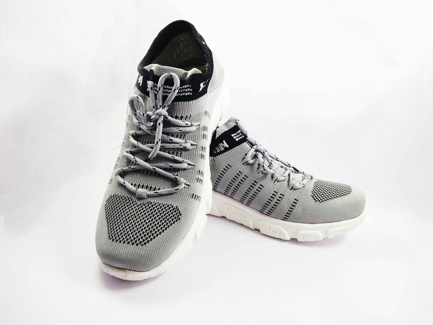 Szare sportowe sneakersy na białym tle, zbliżenie cholewek