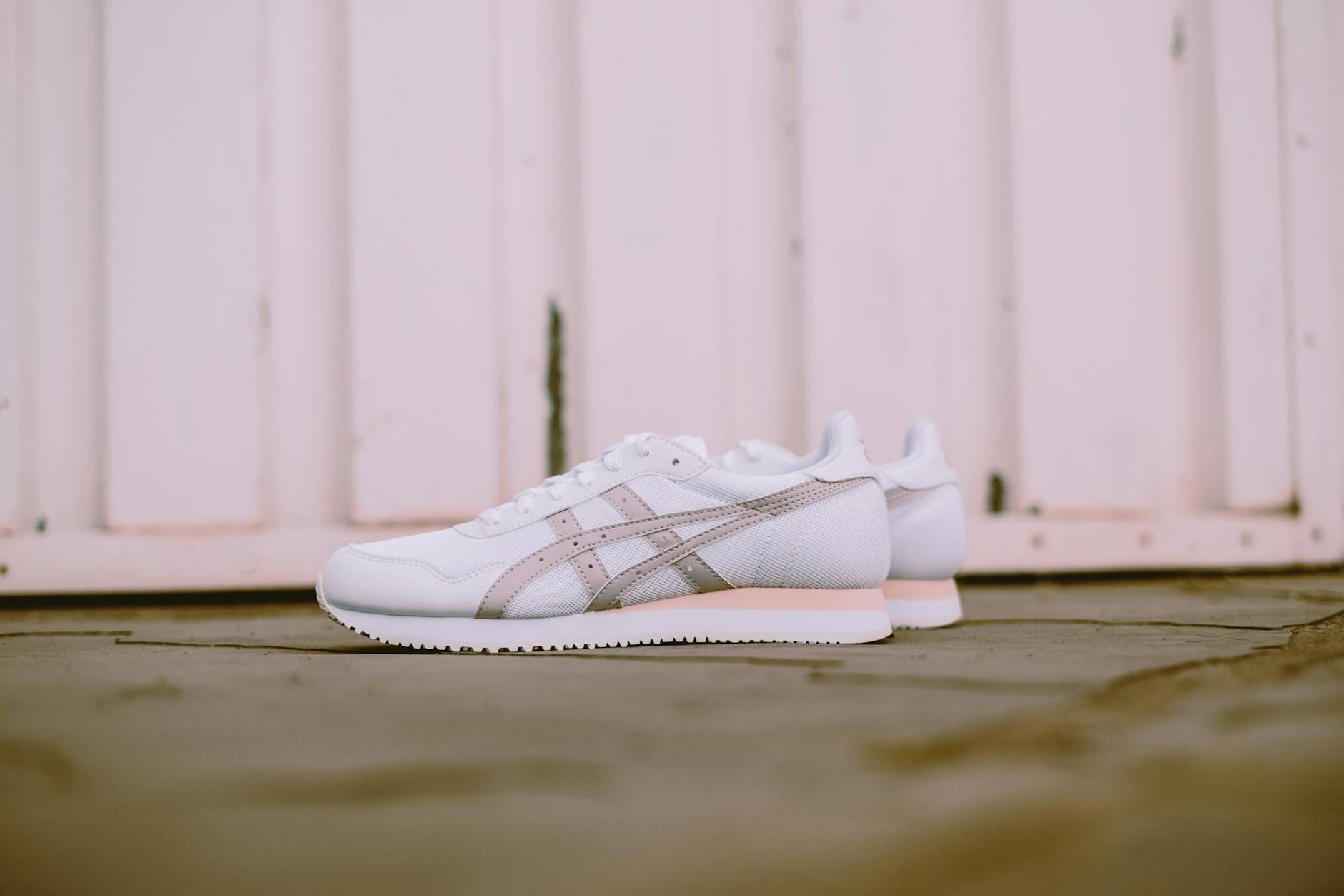 Białe stylowe sneakersy na rustykalnych drewnianych deskach