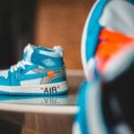 Jaskrawe trampki z wzorem odbijające się na stole w domowym wnętrzu