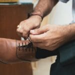 Mężczyzna wiąże sznurówki brązowych skórzanych butów w eleganckim stylu