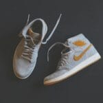 Szare i pomarańczowe sneakersy high-top na minimalistycznym tle