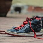 Czarno-czerwone buty do biegania z bliska na brukowanym chodniku