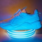 Niebieski sportowy sneaker oświetlony neonowym światłem