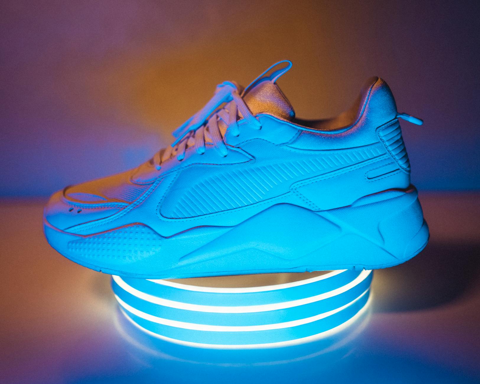 Niebieski sportowy sneaker oświetlony neonowym światłem