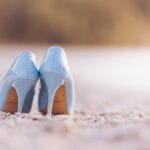 Niebieskie szpilki ustawione na kamienistej, spokojnej plaży