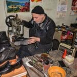 Szewc naprawia skórzane eleganckie buty w tradycyjnym warsztacie