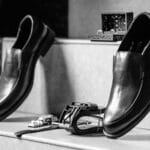 Czarne skórzane buty wizytowe z dodatkami na eleganckim tle