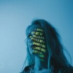 Kobieta z nałożonym na twarz kodem binarnym symbolizującym technologię