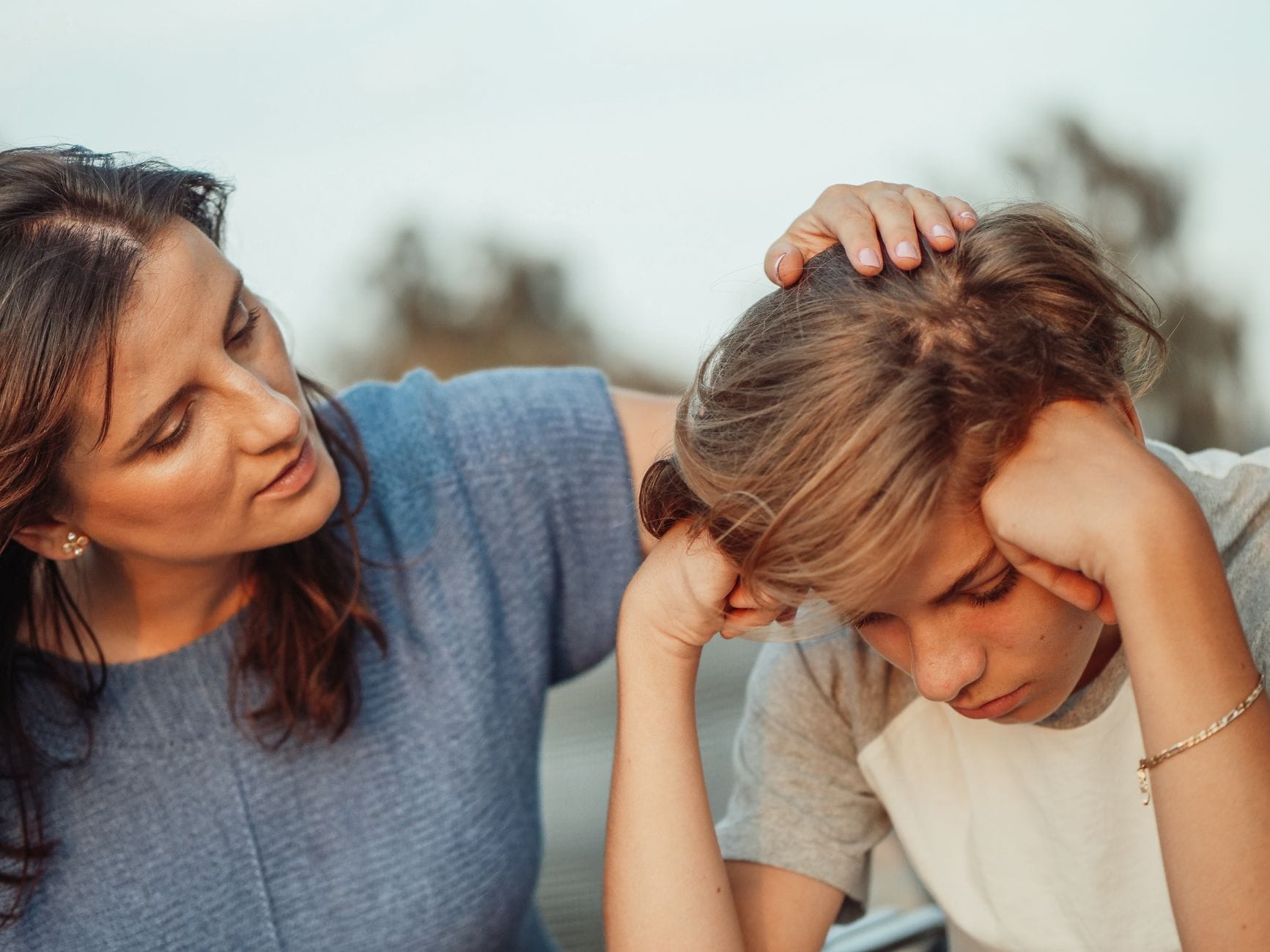 Mama wspierająca przygnębionego nastoletniego syna podczas rozmowy