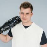 Młoda osoba trzyma futurystyczną protezę nogi w studiu zdjęciowym