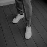 Nowoczesne białe sneakersy z bliska na drewnianym pomoście
