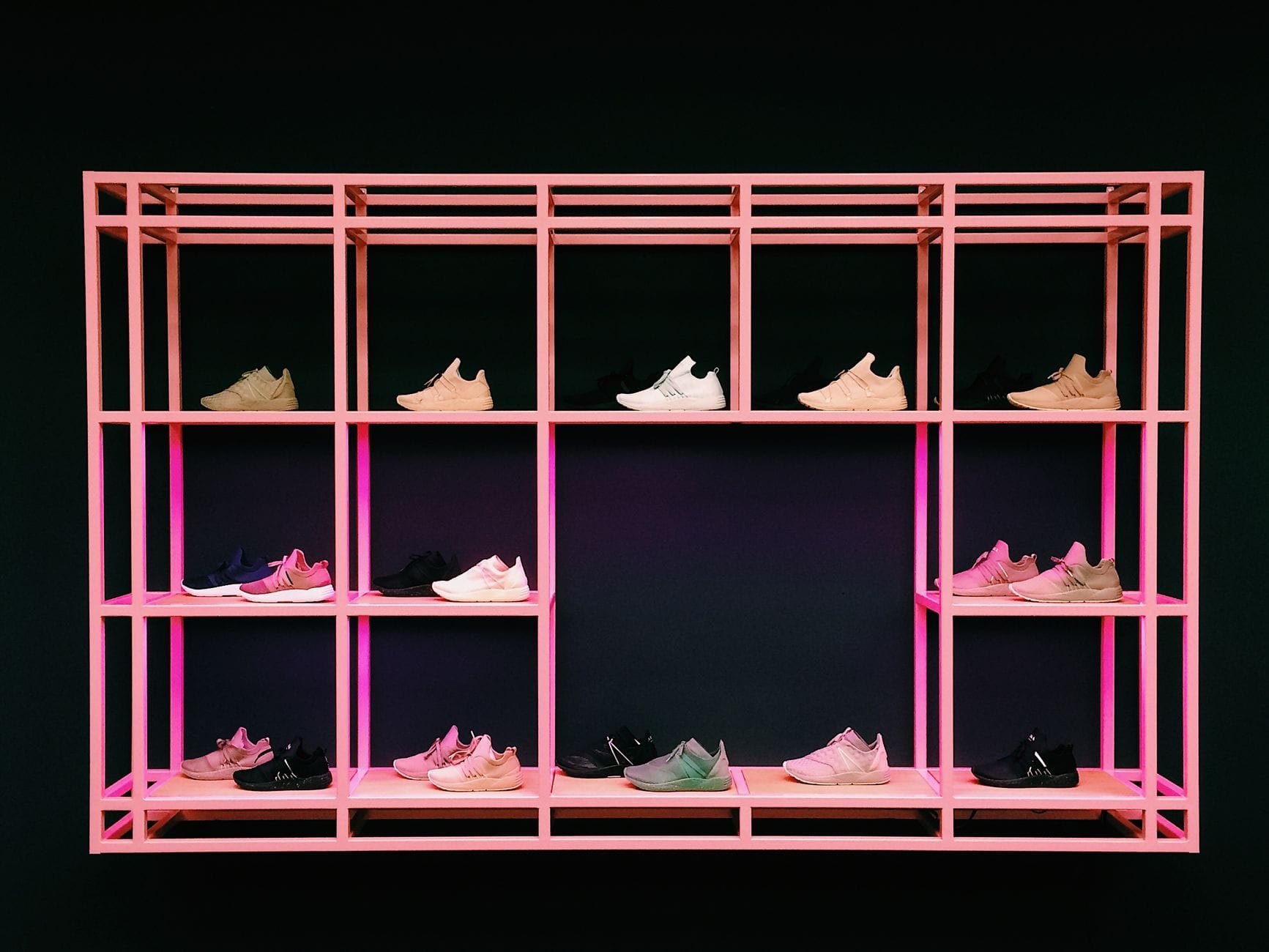 Kolorowe sneakersy na różowej półce, nowoczesne modele do kolekcji
