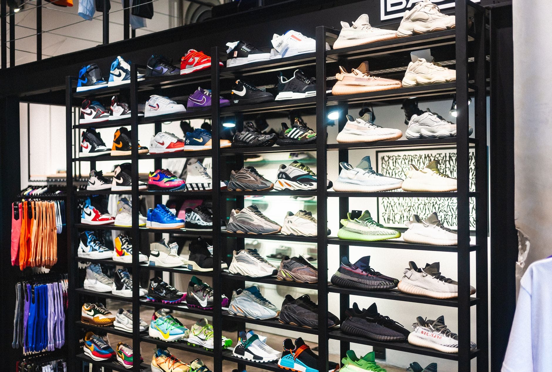Półka z kolorowymi sneakerami różnych marek w nowoczesnym sklepie